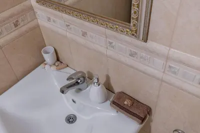 a white sink in a bathroom with a mirror at Vazov Residence , two bedroom top centre apartment in Varna City