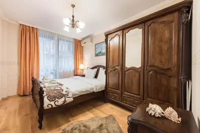 a bedroom with a bed and a large wooden cabinet at Vazov Residence , two bedroom top centre apartment in Varna City