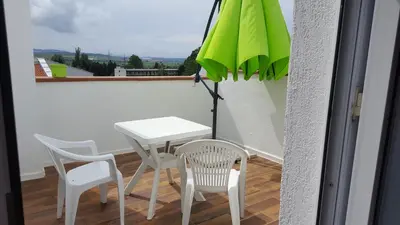 a white table and chairs and an umbrella on a balcony at Penthaus Cacao Beach in Sunny Beach