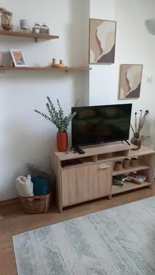 a living room with a flat screen tv on a wooden entertainment center at Guest house Veneta in Sozopol
