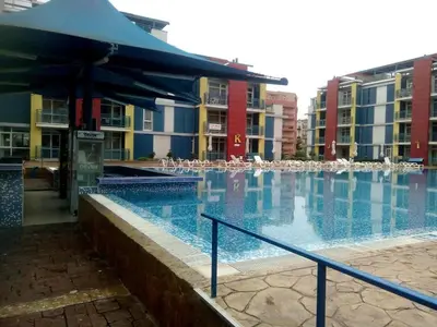 a large swimming pool with chairs and some buildings at Studios in Complex Elit 4 in Sunny Beach