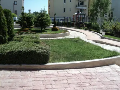 a walkway in a park with grass and bushes at Studios in Complex Elit 4 in Sunny Beach