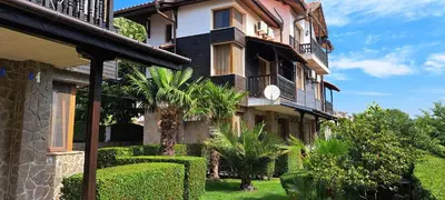 a building with bushes and trees in front of it at Sani Holiday Village in Sozopol