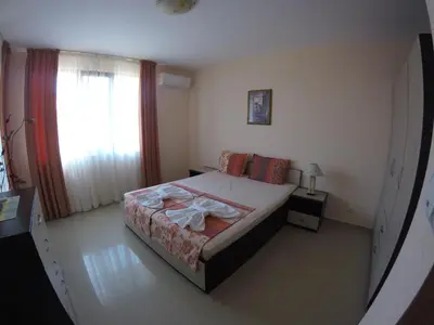 a small bedroom with a bed and a window at Sani Holiday Village in Sozopol