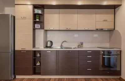 a kitchen with wooden cabinets and a stainless steel refrigerator at Apartment Aventurine in Varna City