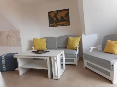 a living room with a couch and a table at Studio Stoianovi in Nesebar