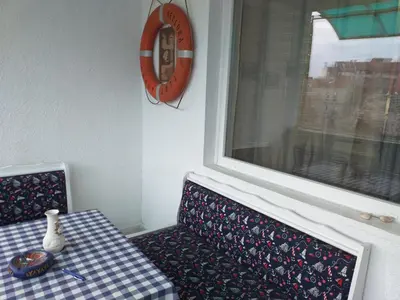 a table and a chair next to a window at Апартамент Термите in Varna City