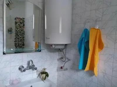 a white bathroom with a sink and a mirror at Апартамент Термите in Varna City