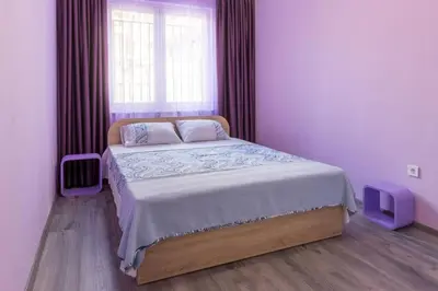 a bedroom with a large bed with a window at Kapriz - 2 beds aptmnt near the beach in Varna City