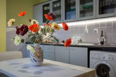 a vase of flowers sitting on a table in a kitchen at Kapriz - 2 beds aptmnt near the beach in Varna City