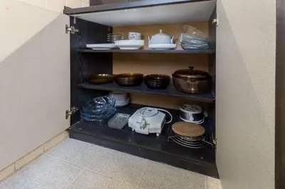 a cabinet filled with dishes and pots and pans at Kapriz - 2 beds aptmnt near the beach in Varna City