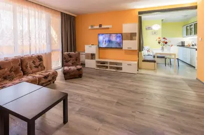 a living room with a couch and a flat screen tv at Kapriz - 2 beds aptmnt near the beach in Varna City