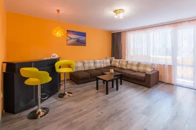 a living room with a couch and a table and chairs at Kapriz - 2 beds aptmnt near the beach in Varna City