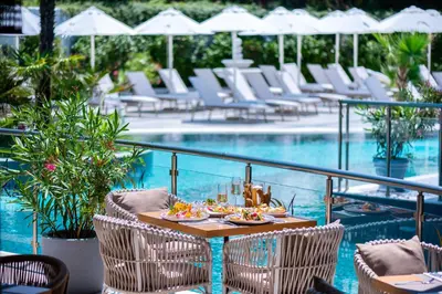 a table with food on it next to a swimming pool at Siena Premium Retreat in Lozenets