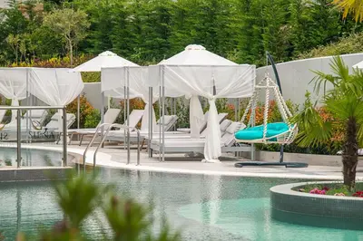 a pool with chairs and a swing in a resort at Siena Premium Retreat in Lozenets