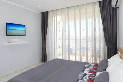 a bedroom with a bed and a large window at Niko's Apartments Deluxe in Nesebar