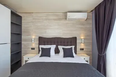 a bedroom with a large bed with two night stands at Niko's Apartments Deluxe in Nesebar