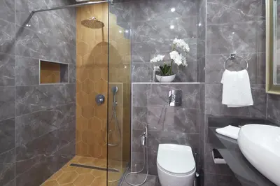 a bathroom with a shower and a toilet and a sink at Niko's Apartments Deluxe in Nesebar