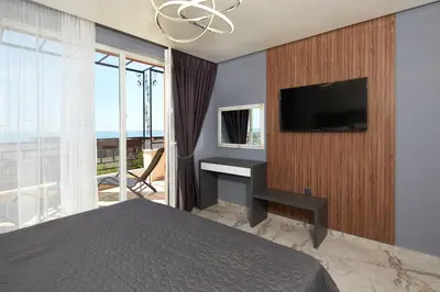 a bedroom with a bed and a tv on a wall at Niko's Apartments Deluxe in Nesebar