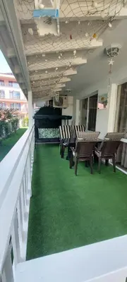 a row of chairs on a balcony with green carpet at Апартамент Морска Звезда in Nesebar