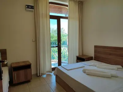 a bedroom with a bed and a large window at Гардън Бийч - НЕДЯЛКОВИ in Sozopol
