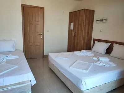 a bedroom with two beds with white sheets at Гардън Бийч - НЕДЯЛКОВИ in Sozopol