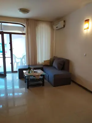 a living room with a couch and a coffee table at Гардън Бийч - НЕДЯЛКОВИ in Sozopol