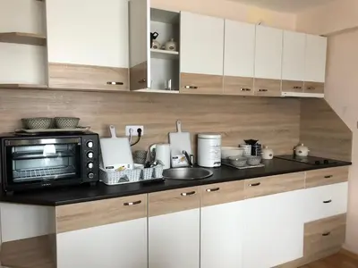a kitchen with white cabinets and a microwave at Palace De Luxe - Apartments in Pomorie