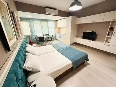 a bedroom with a large bed and a kitchen at STUDIO KATRIN in Nesebar
