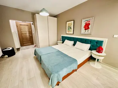 a bedroom with a large bed with a blue headboard at STUDIO KATRIN in Nesebar