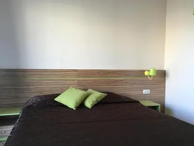 a bedroom with a black bed with two green pillows at Tia Maria is situated in the southern part of the Sunny Beach Resort in Sunny Beach