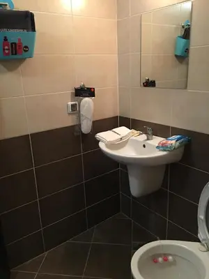a bathroom with a sink and a toilet at Salt Lake ApartHotel in Pomorie