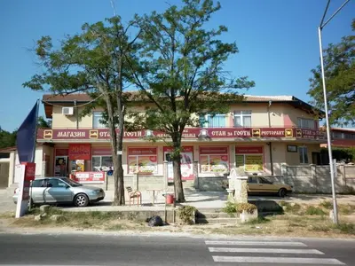 a building with cars parked in front of it at Ivanova Cheshma Guest House in Varna City