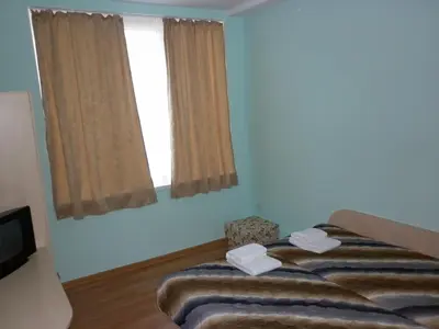 a bedroom with a bed and a window at Ivanova Cheshma Guest House in Varna City