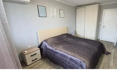 a bedroom with a bed and a nightstand and a bed sidx sidx at K&K Stylish Elegance in Burgas City