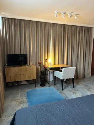 a hotel room with a bed and a table and a television at Hotel Art in Varna City