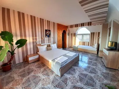a bedroom with a bed and a tv in it at Art Villa Rozalia in Ravda