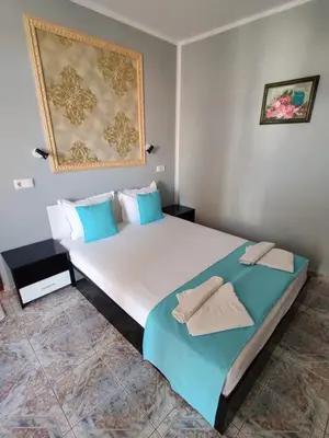 a bedroom with a large bed with towels on it at Art Villa Rozalia in Ravda