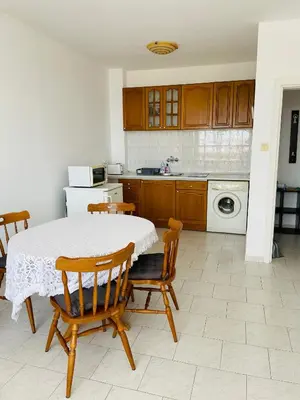 a kitchen with a table and chairs and a kitchen with a stove at Sun Palace apartments in Sveti Vlas