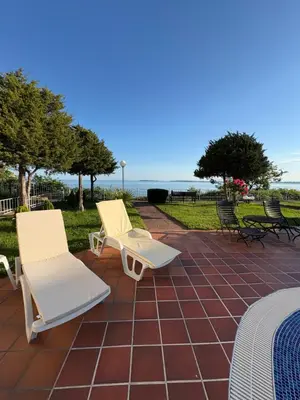 two chairs and a bed on a brick patio at Sun Palace apartments in Sveti Vlas