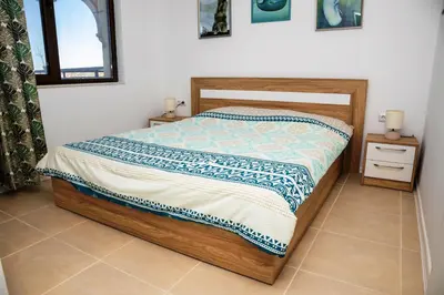a bedroom with a bed and two night stands at Green Life One-Bedroom Apartment with Sea View by Flаt Manаger in Sozopol