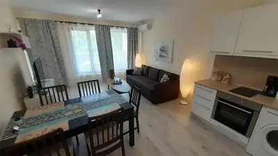 a kitchen and a living room with a table and chairs at RELAX Apartment in Varna South Bay Residence in Varna City