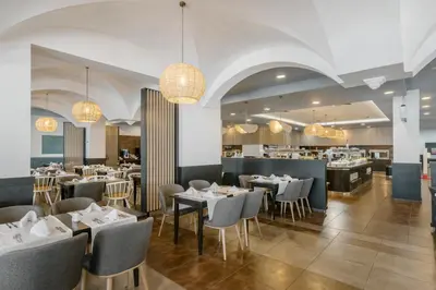 a restaurant with tables and chairs and a bar at Alua Helios Bay - All Inclusive in Obzor