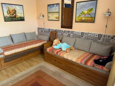 a teddy bear sitting on a couch in a room at Аппартамент в Триумфе Святой Влас 300м от моря, бассейн. in Sveti Vlas