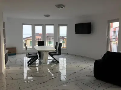 a white room with a table and chairs and a tv at Incanto Apartments in Sveti Vlas