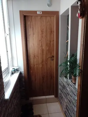 a wooden door with a sign on it in a hallway at Top Center Apartment and Rooms Varna in Varna City