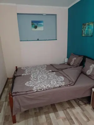 a bedroom with a bed with a picture on the wall at Top Center Apartment and Rooms Varna in Varna City