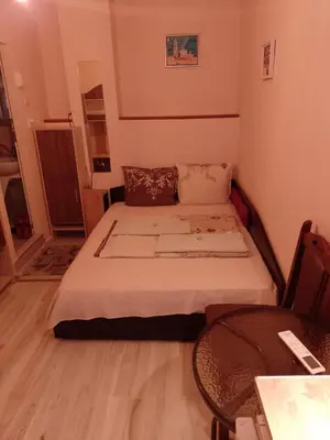a small bedroom with a bed and a table at Top Center Apartment and Rooms Varna in Varna City