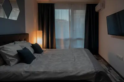 a bedroom with a large bed and a window at SOS CoMFORT in Burgas City