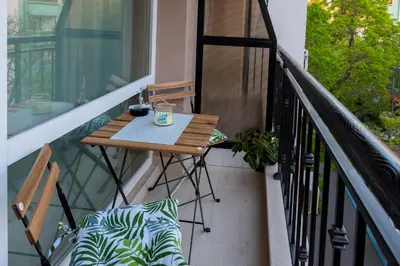 a balcony with a wooden table and a chair at SOS CoMFORT in Burgas City